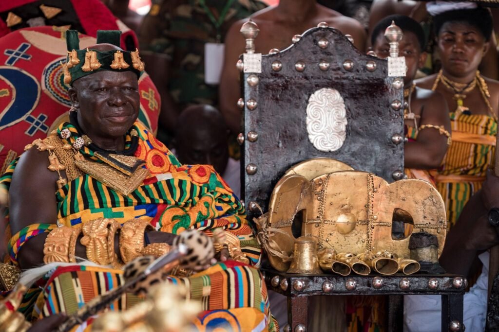 The Asantehene seated in elaborate Kente cloth during a royal festival at Manhyia Palace in Kumasi