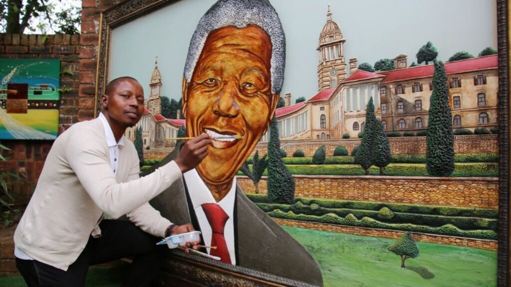 Artist painting a large portrait of Nelson Mandela in front of the Union Buildings backdrop in South Africa.